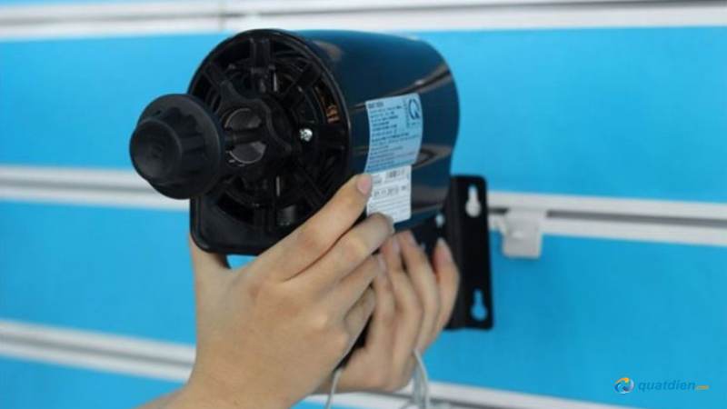 Đặt động cơ quạt lên giá đỡ và giữ chặt bằng hai tay